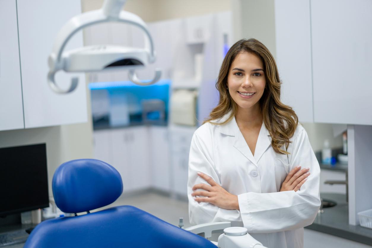 Portrait of a happy Latin American female dentist working at her office and looking at the camera smiling - healthcare and medicine concepts